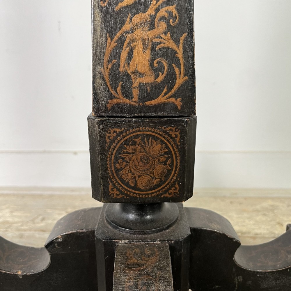 An early nineteenth-century octagonal ebonised tilt-top table featuring intricate ink-drawn classical figures and floral penwork borders. View VIII