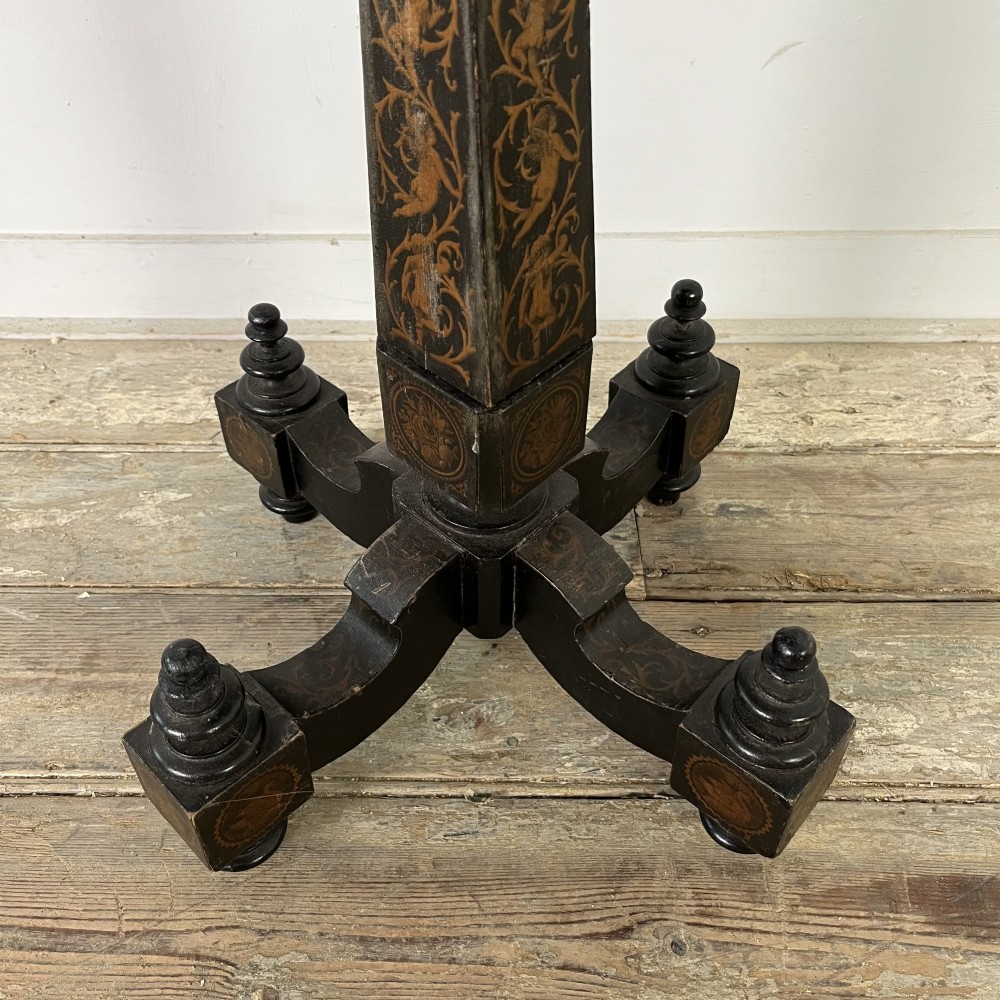 An early nineteenth-century octagonal ebonised tilt-top table featuring intricate ink-drawn classical figures and floral penwork borders. View IX
