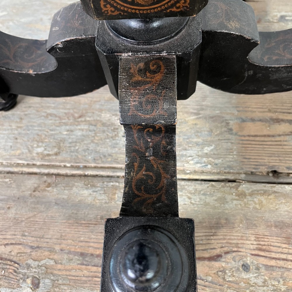 An early nineteenth-century octagonal ebonised tilt-top table featuring intricate ink-drawn classical figures and floral penwork borders. View X