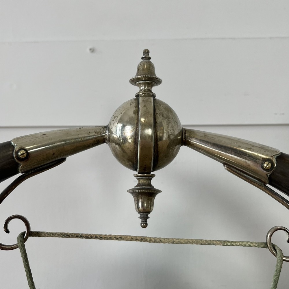 A Victorian tabletop dinner gong featuring two curved natural horns mounted on a polished oak base, holding a central hammered brass disc with an accompanying wooden striker. View II
