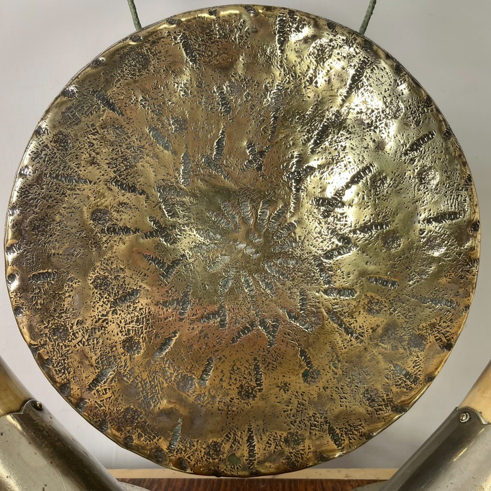 A Victorian tabletop dinner gong featuring two curved natural horns mounted on a polished oak base, holding a central hammered brass disc with an accompanying wooden striker. View III