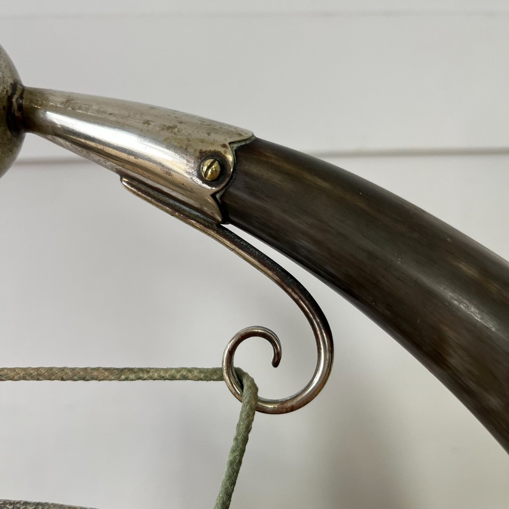 A Victorian tabletop dinner gong featuring two curved natural horns mounted on a polished oak base, holding a central hammered brass disc with an accompanying wooden striker. View X