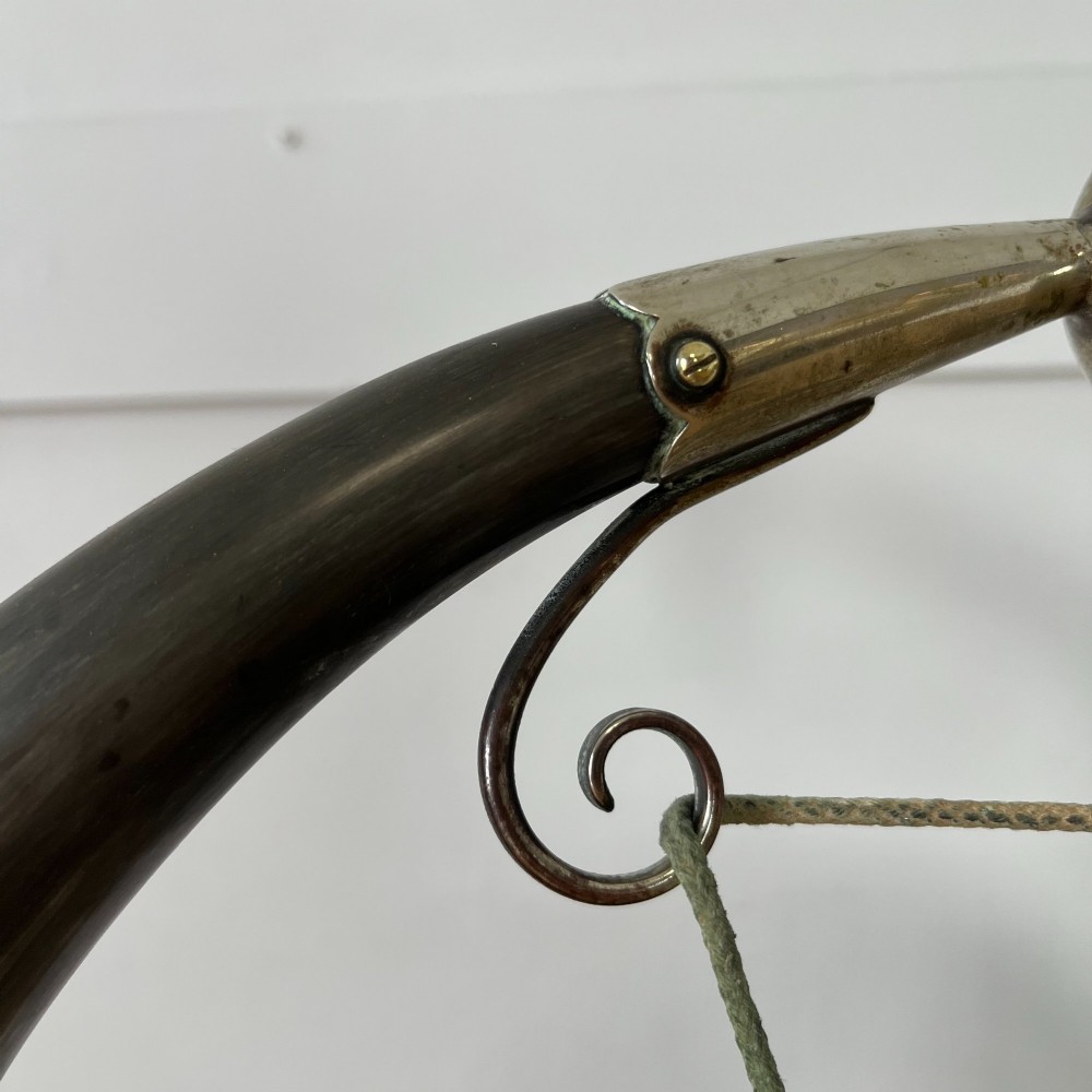 A Victorian tabletop dinner gong featuring two curved natural horns mounted on a polished oak base, holding a central hammered brass disc with an accompanying wooden striker. View XI