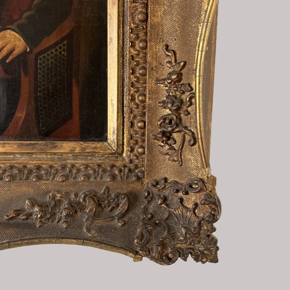 A 19th-century oil portrait depicting a seated gentleman in dark attire against a dark background, set within a heavily carved giltwood frame. View VII