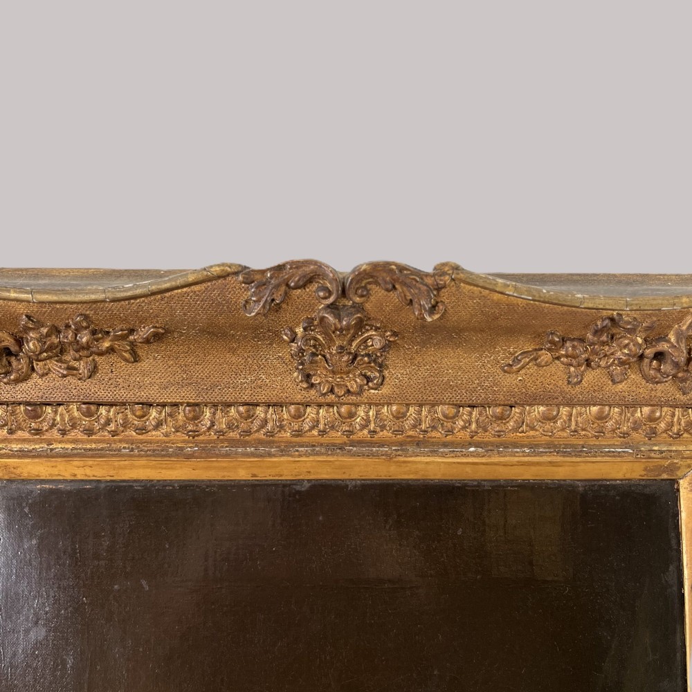 A 19th-century oil portrait depicting a seated gentleman in dark attire against a dark background, set within a heavily carved giltwood frame. View IX