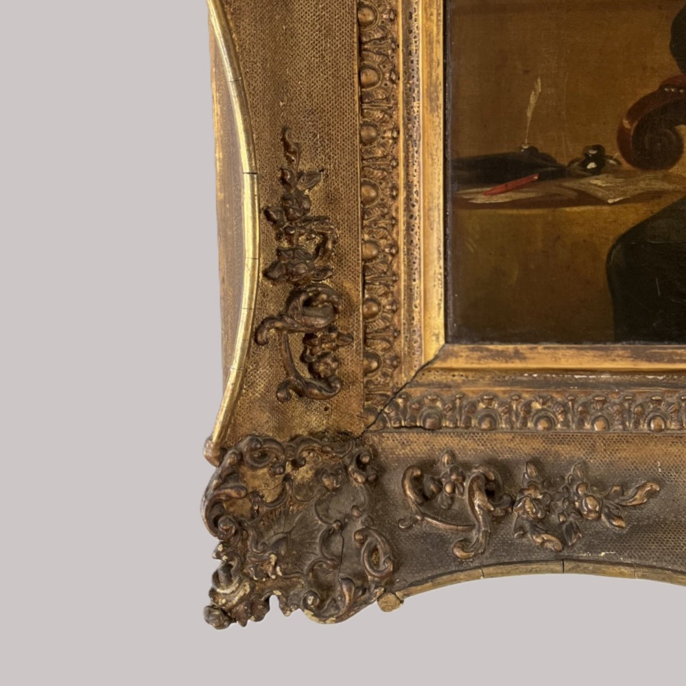 A 19th-century oil portrait depicting a seated gentleman in dark attire against a dark background, set within a heavily carved giltwood frame. View XI