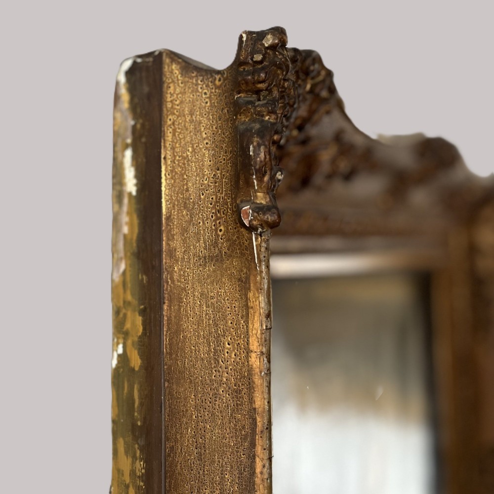 A 19th-century oil portrait depicting a seated gentleman in dark attire against a dark background, set within a heavily carved giltwood frame. View XIII