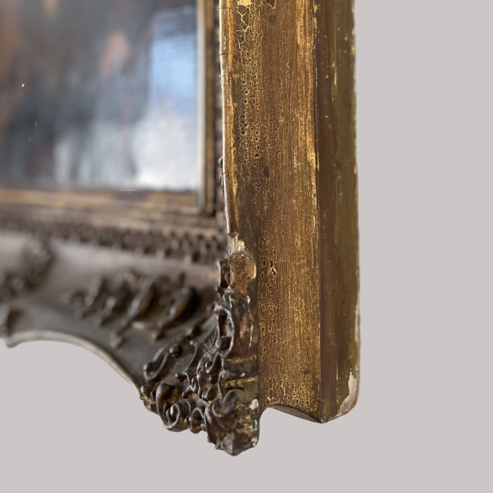A 19th-century oil portrait depicting a seated gentleman in dark attire against a dark background, set within a heavily carved giltwood frame. View XV