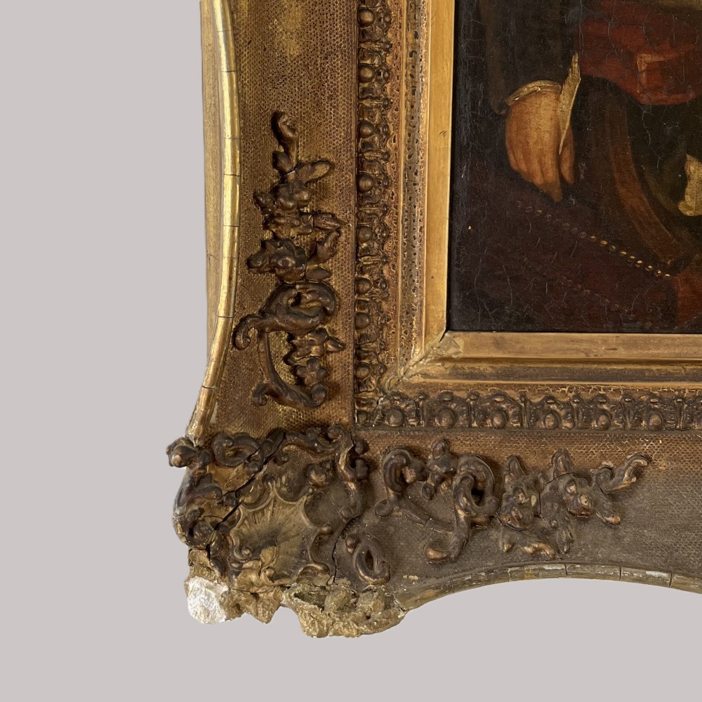 A nineteenth-century oil portrait depicting a seated gentleman resting his chin on his hand, presented in an elaborate gilded swept frame. View VI