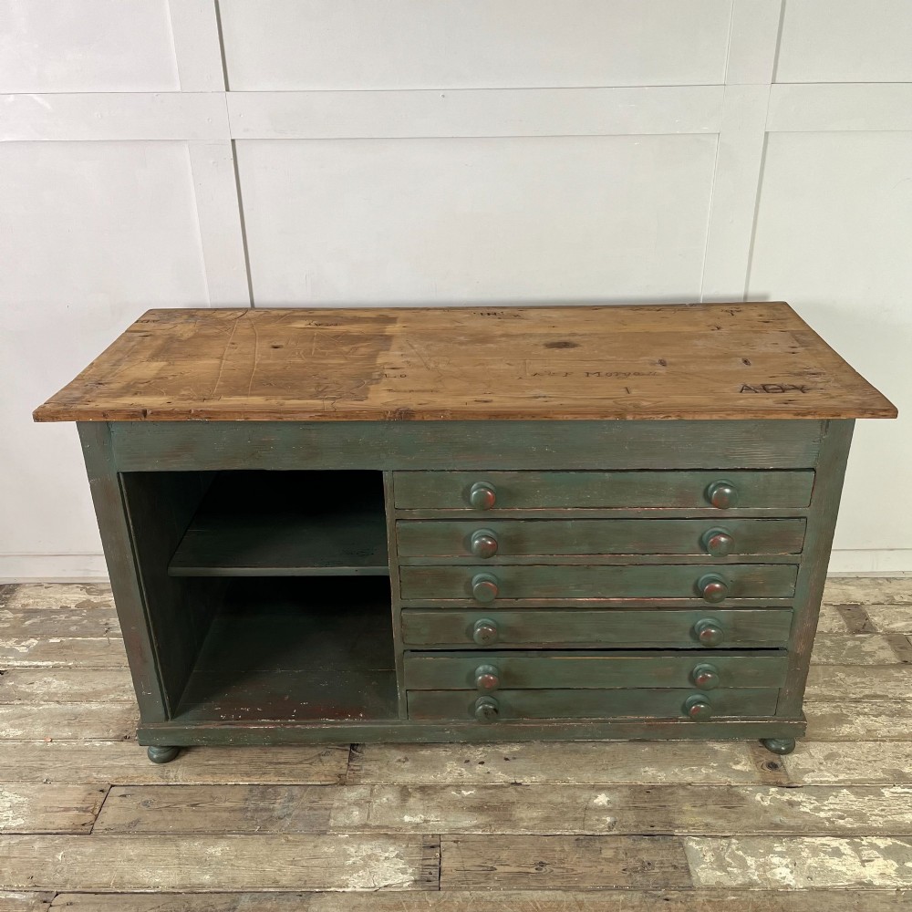 A low Victorian dark green painted pine artist chest featuring six shallow drawers on the right, an open shelf compartment on the left, and an unpainted timber top. View VI