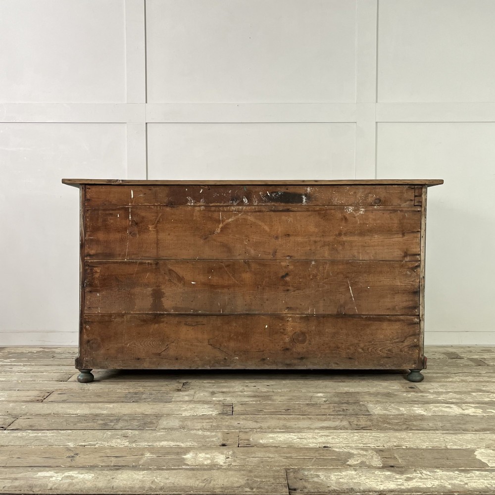 A low Victorian dark green painted pine artist chest featuring six shallow drawers on the right, an open shelf compartment on the left, and an unpainted timber top. View XIV