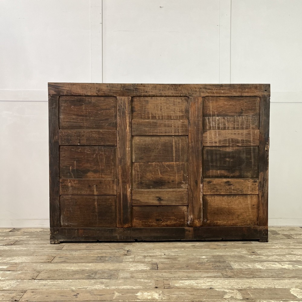 An early nineteenth-century carved oak high-back settle featuring carved back panels, curved arms, and an integrated box storage seat. View XV