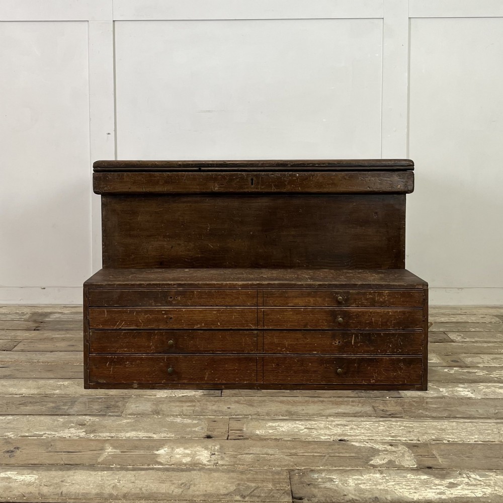 An early 20th-century pine carpenters chest featuring an upper hinged lid and multiple shallow lower drawers with small round knobs. View VII
