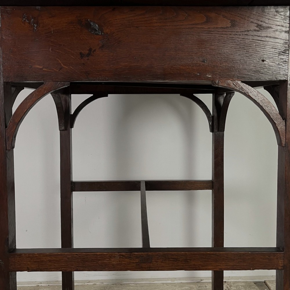 An early 19th century dark oak side table featuring a single drawer with a brass handle, arched aprons, and straight square legs connected by a low stretcher. View VIII