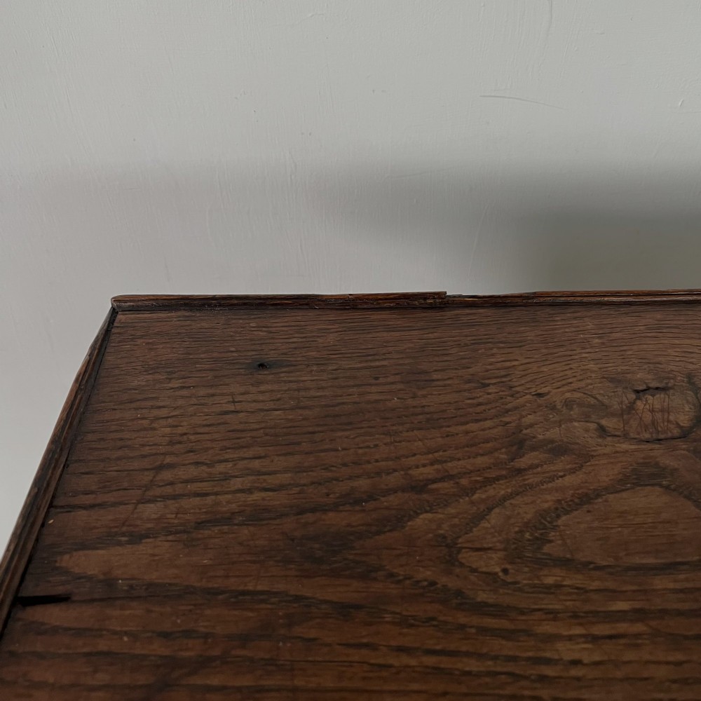 An early 19th century dark oak side table featuring a single drawer with a brass handle, arched aprons, and straight square legs connected by a low stretcher. View XI