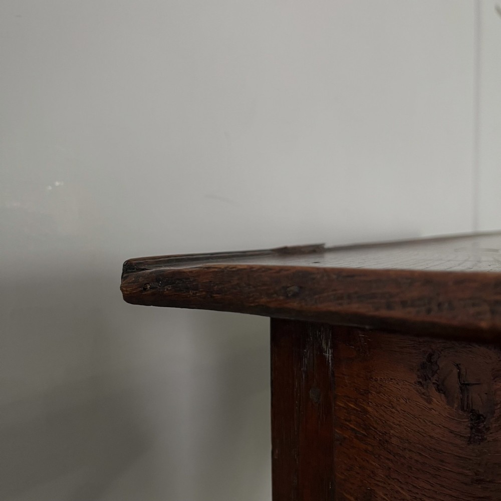 An early 19th century dark oak side table featuring a single drawer with a brass handle, arched aprons, and straight square legs connected by a low stretcher. View XII