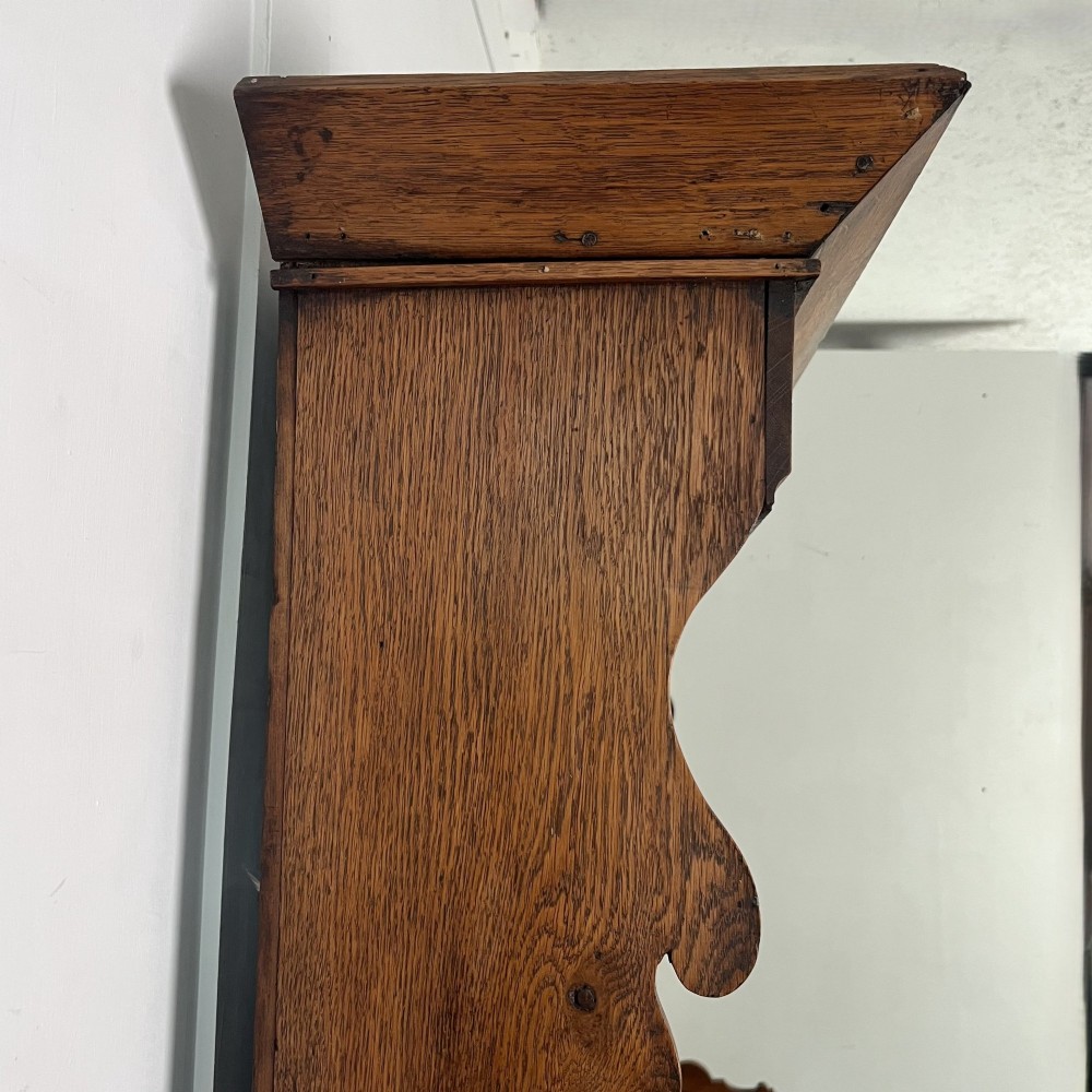 An early nineteenth-century oak kitchen dresser featuring an open upper plate rack over a base with central drawers and side cupboard doors with brass hardware. View IX
