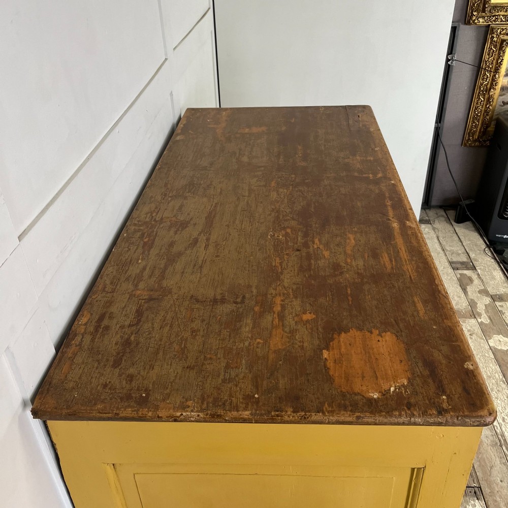 A large Victorian pine school cupboard featuring a mustard yellow painted finish, two panelled doors with wooden knobs, and a dark waxed wooden top. View VII