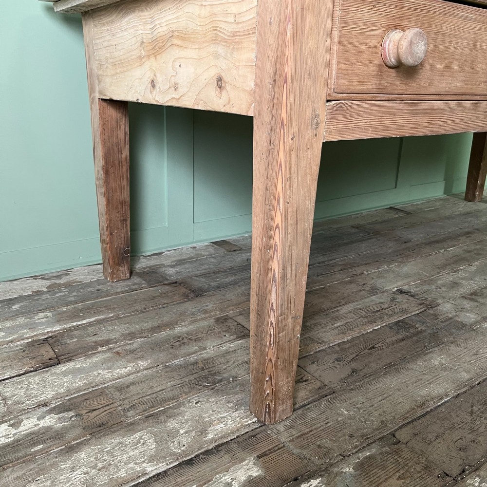 An early nineteenth-century timber prep table featuring three drawers with round wooden knobs set above four tapered legs. View V
