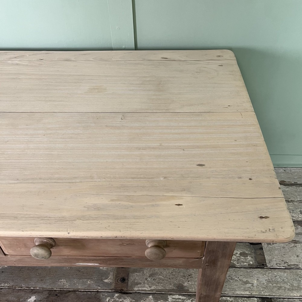 An early nineteenth-century timber prep table featuring three drawers with round wooden knobs set above four tapered legs. View XII