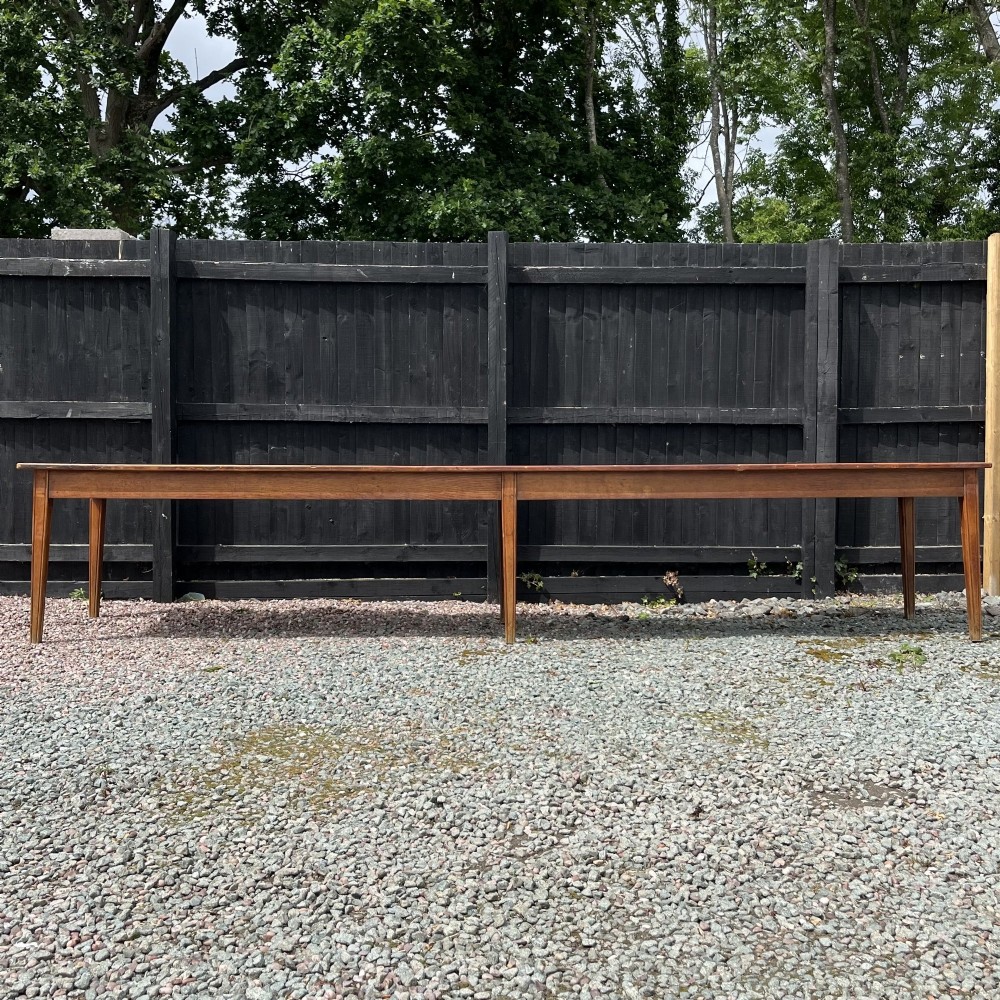 A 3.8-metre long 19th-century French cherrywood farmhouse dining table supported by six tapered square legs.
