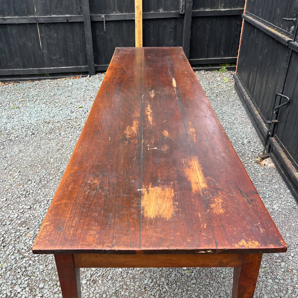 An exceptionally long 19th-century French cherrywood farmhouse table featuring a flat wooden top, straight aprons, and four square tapered legs. View II