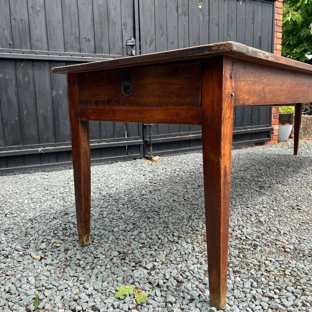 An exceptionally long 19th-century French cherrywood farmhouse table featuring a flat wooden top, straight aprons, and four square tapered legs. View V