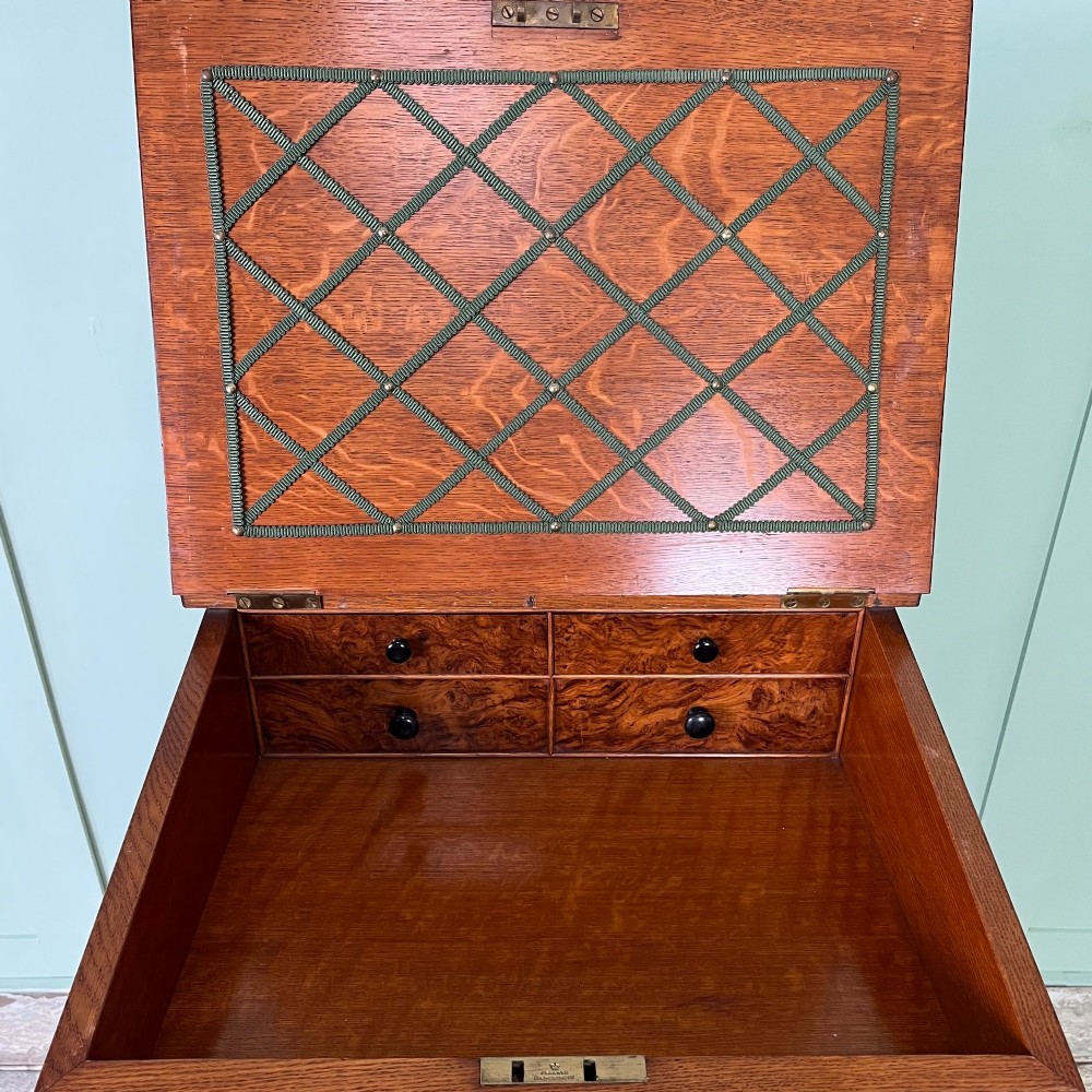 A 19th-century burr walnut Davenport desk featuring a sloped writing lid with a spindled gallery rail, side drawers, and turned feet. View III