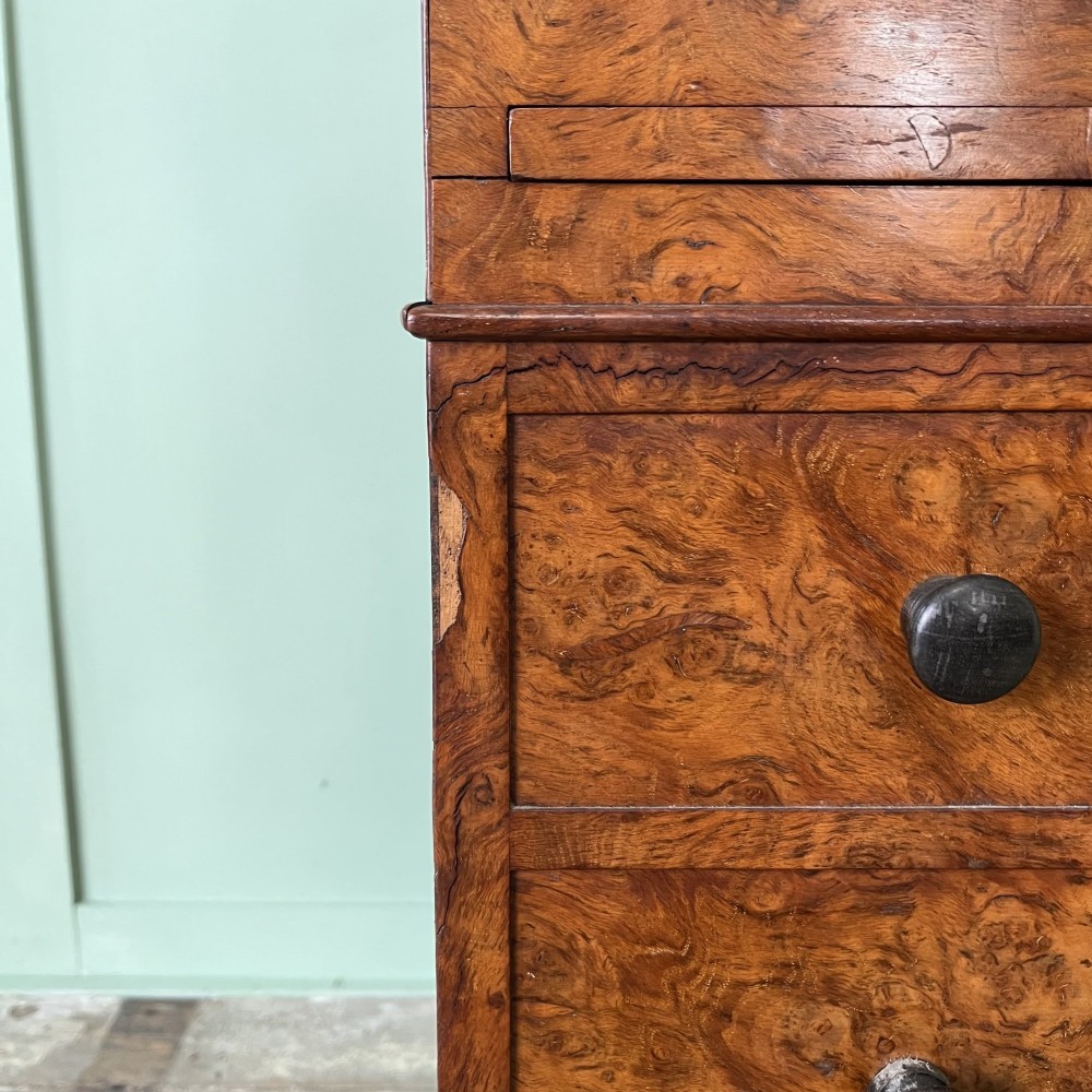 A 19th-century burr walnut Davenport desk featuring a sloped writing lid with a spindled gallery rail, side drawers, and turned feet. View XIV