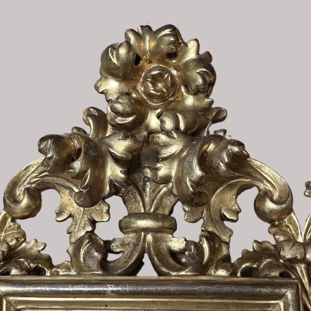 A 19th-century Florentine carved giltwood picture frame featuring openwork acanthus leaves, scrollwork cresting, and a central circular image of the Madonna and Child. View IV