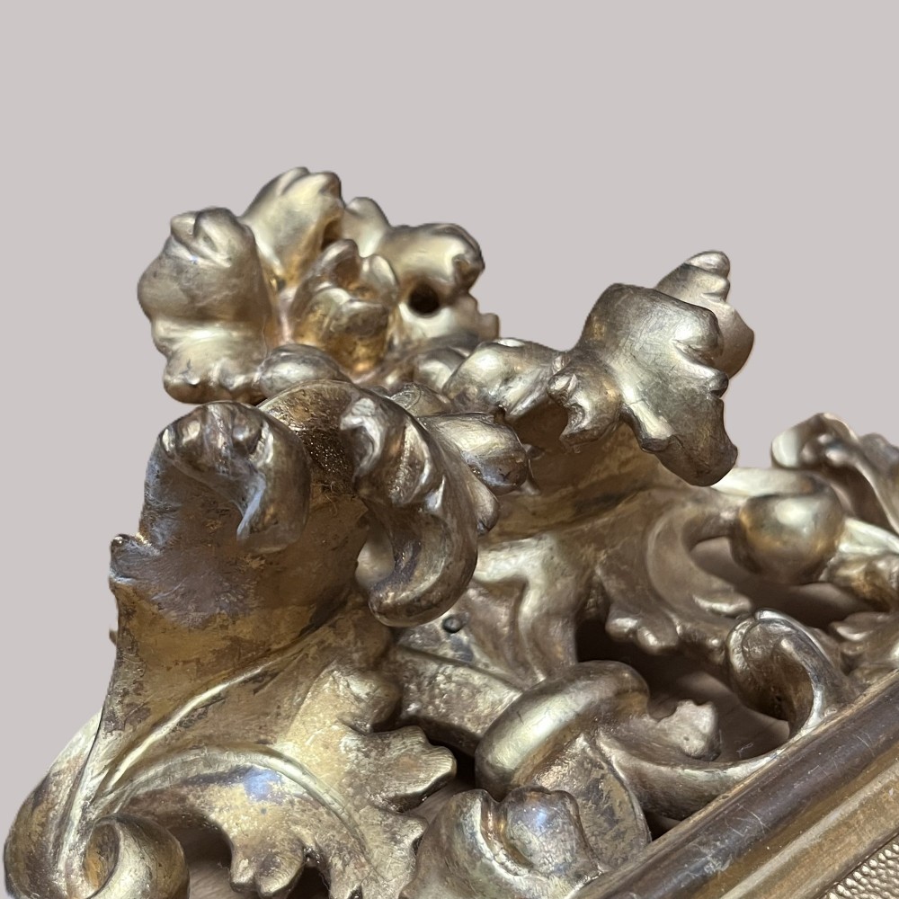 A 19th-century Florentine carved giltwood picture frame featuring openwork acanthus leaves, scrollwork cresting, and a central circular image of the Madonna and Child. View XI