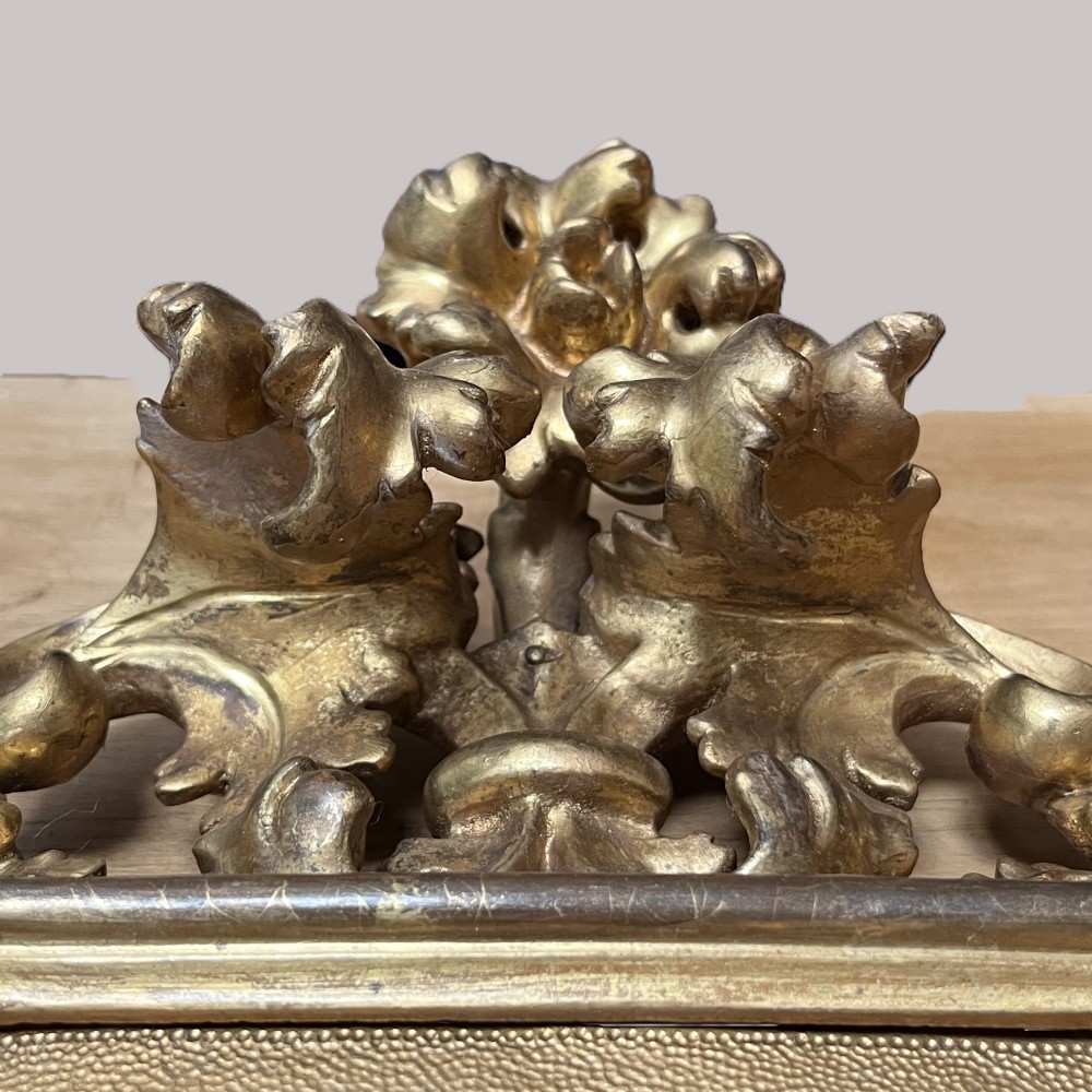 A 19th-century Florentine carved giltwood picture frame featuring openwork acanthus leaves, scrollwork cresting, and a central circular image of the Madonna and Child. View XII