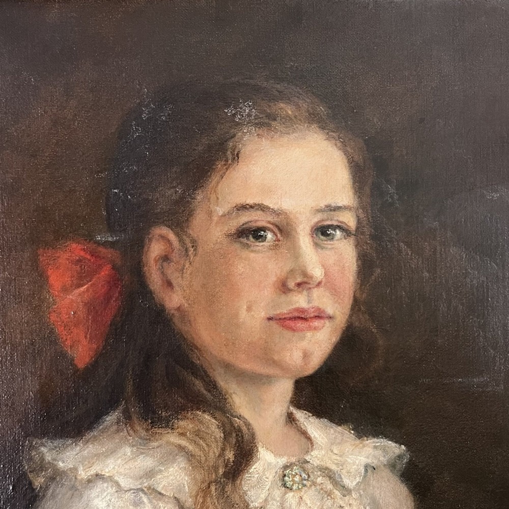 An Edwardian oil painting on canvas featuring a seated young girl in a cream lace-collared dress, housed in a dark wooden frame with a gold inner slip. View II