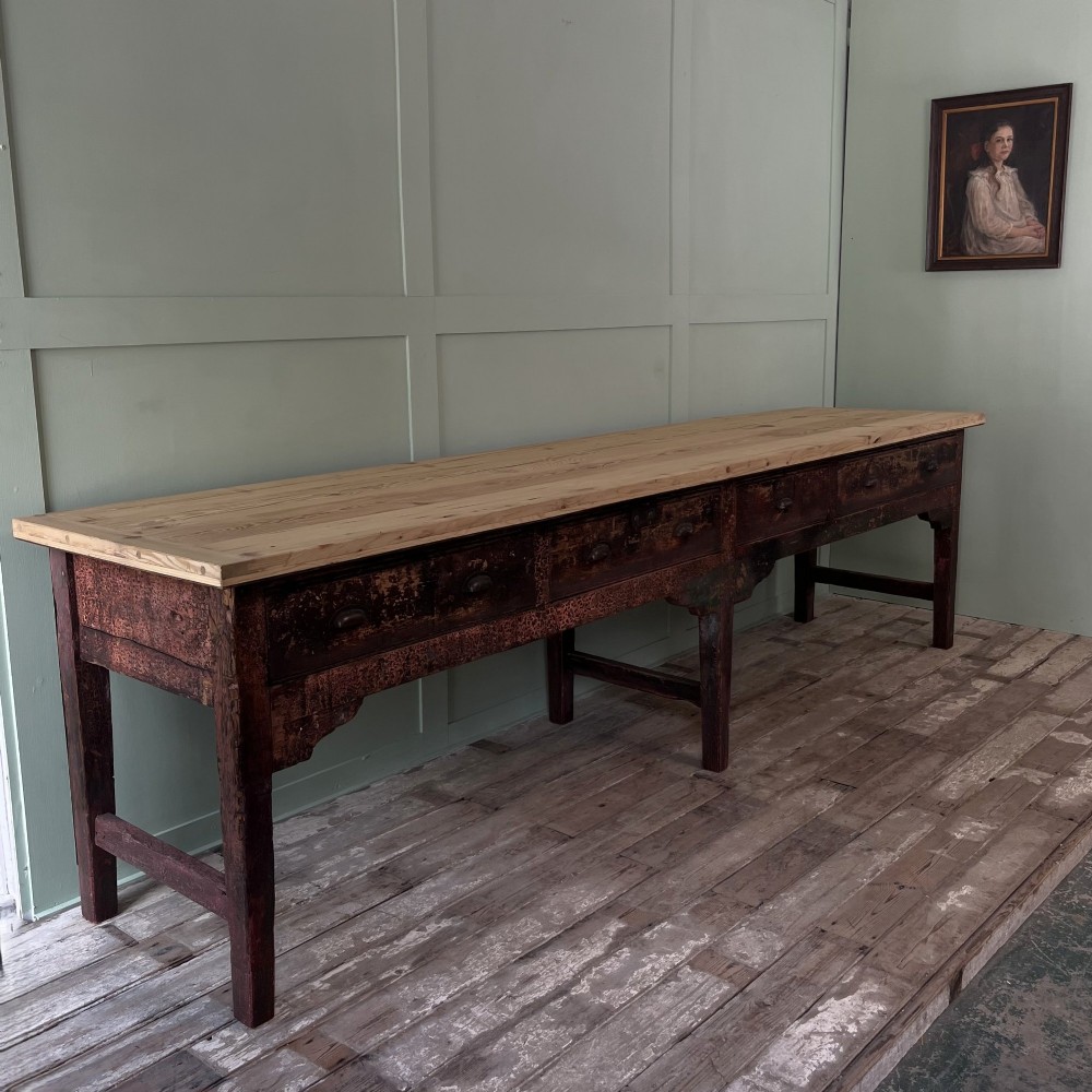 An early 19th-century pine serving table featuring a natural scrubbed timber top and a dark painted base with six legs and four drawers. View II