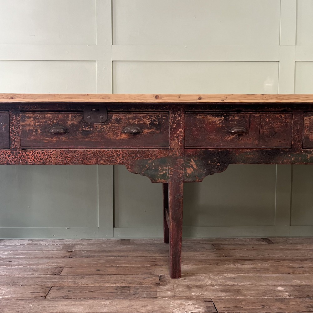 An early 19th-century pine serving table featuring a natural scrubbed timber top and a dark painted base with six legs and four drawers. View VII