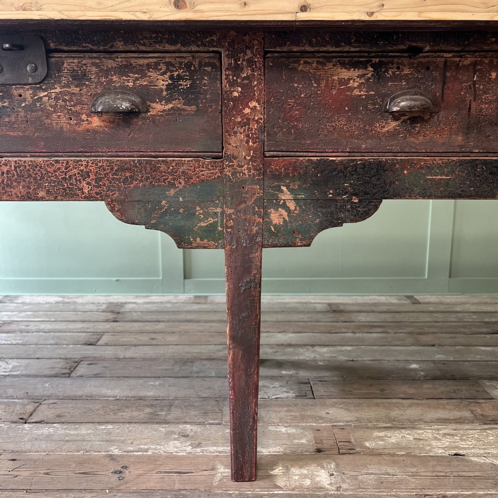 An early 19th-century pine serving table featuring a natural scrubbed timber top and a dark painted base with six legs and four drawers. View X