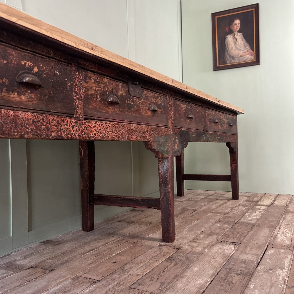 An early 19th-century pine serving table featuring a natural scrubbed timber top and a dark painted base with six legs and four drawers. View XIV