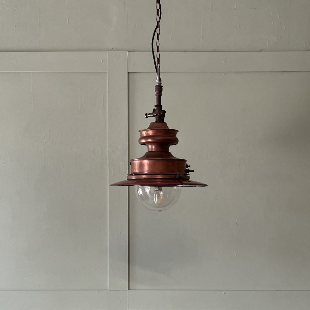 A Victorian copper hanging lantern featuring a stepped metal body, hanging chain, and a clear glass bowl shade.