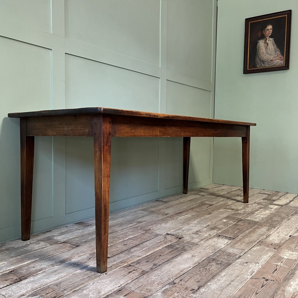 A nineteenth-century French cherrywood farmhouse dining table featuring tapered square legs and a rectangular plank top. View III