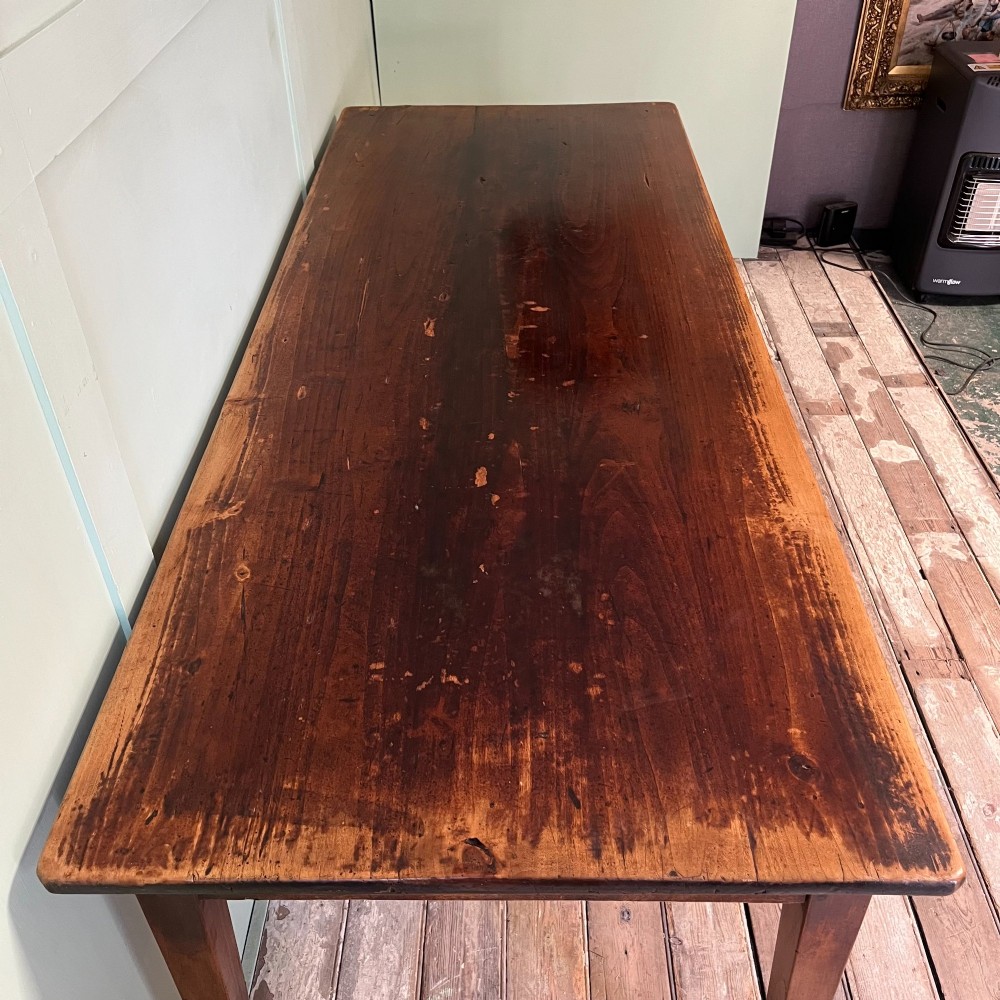 A nineteenth-century French cherrywood farmhouse dining table featuring tapered square legs and a rectangular plank top. View V