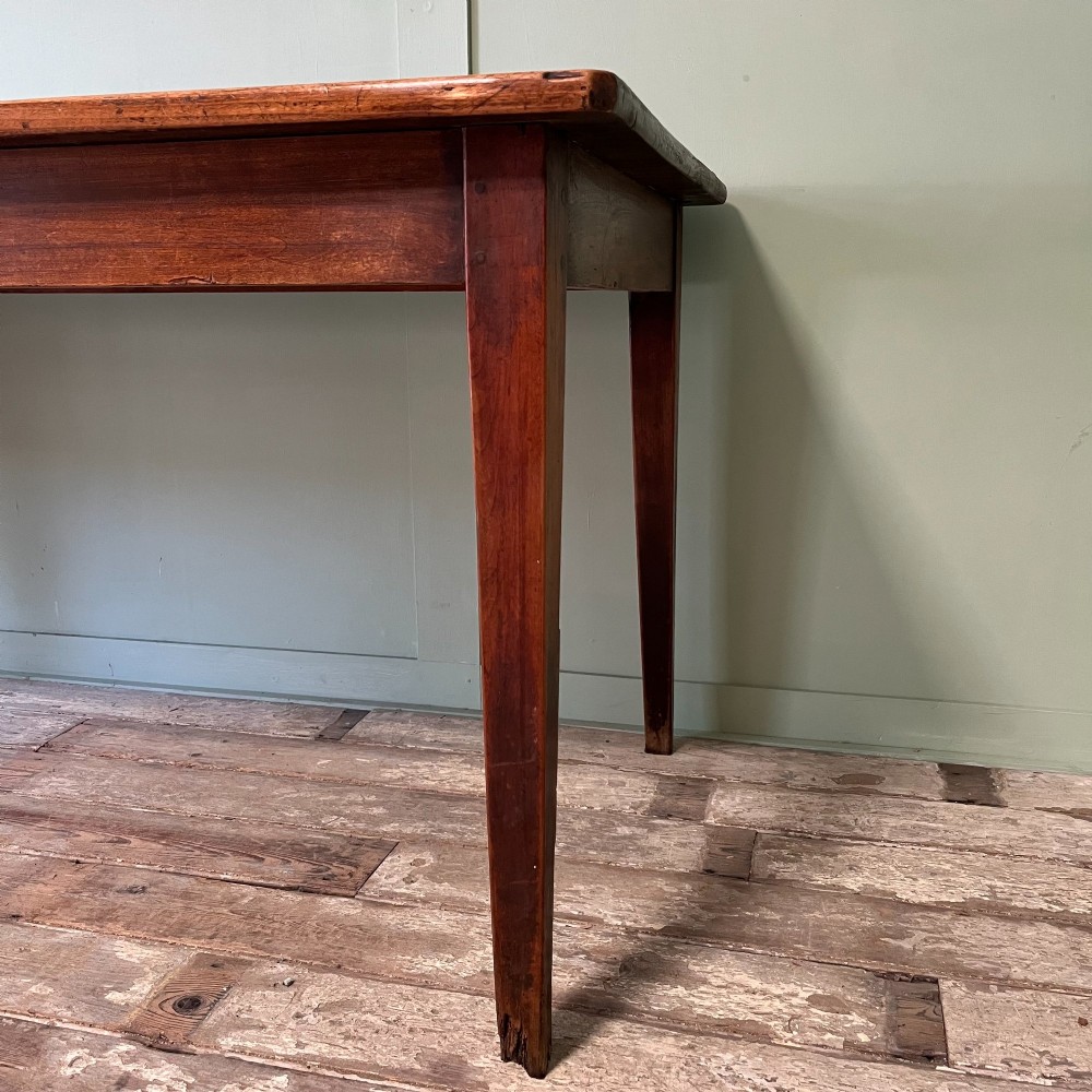 A nineteenth-century French cherrywood farmhouse dining table featuring tapered square legs and a rectangular plank top. View VI