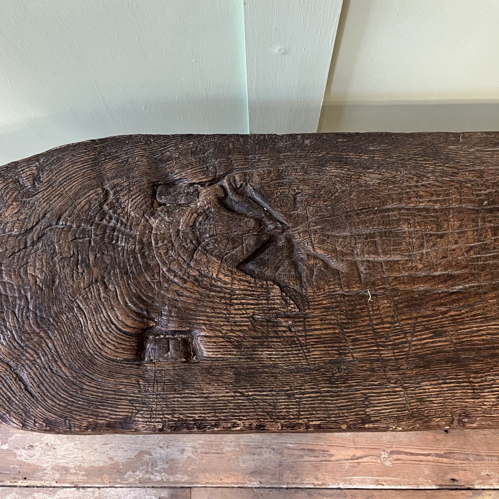 A long rustic dark oak bench featuring an unrefined thick slab seat supported by four simple splayed legs. View VIII