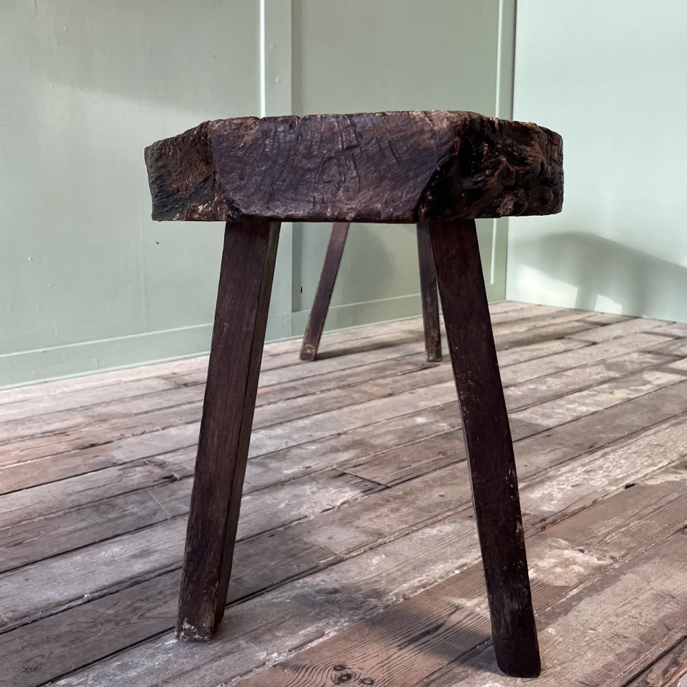 A long rustic dark oak bench featuring an unrefined thick slab seat supported by four simple splayed legs. View XI