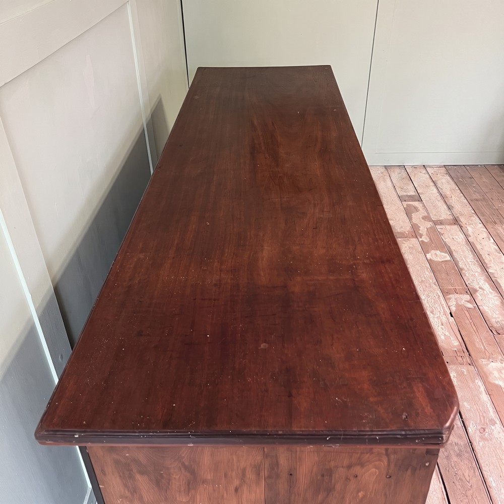 A Victorian shop counter featuring a dark painted pine base with two large glass panel doors and a polished mahogany top surface. View IV
