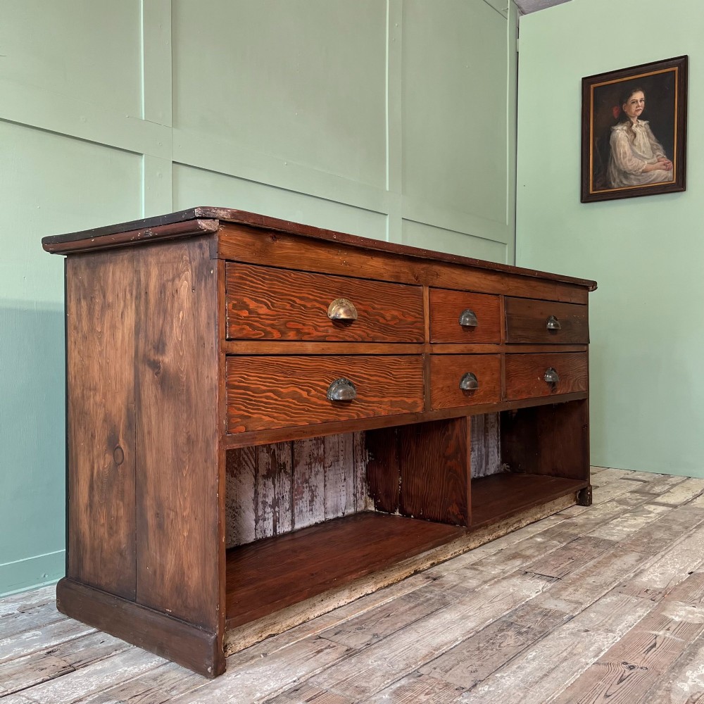 A Victorian shop counter featuring a dark painted pine base with two large glass panel doors and a polished mahogany top surface. View XI