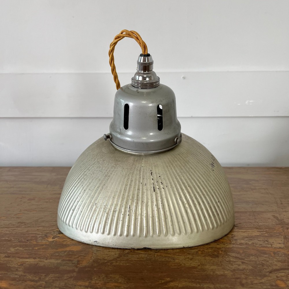 A pair of silver ribbed angled aluminium pendant light shades with vented gallery tops and twisted flex. View V