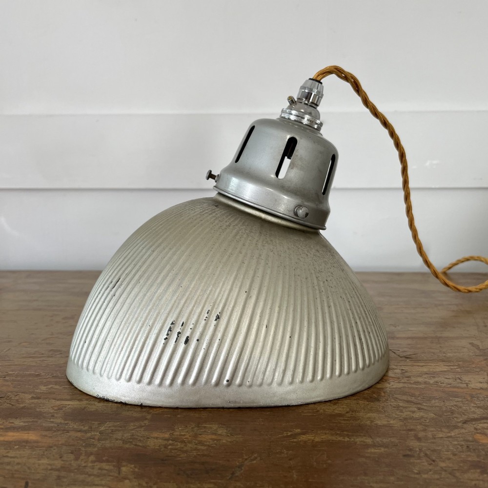 A pair of silver ribbed angled aluminium pendant light shades with vented gallery tops and twisted flex. View VI