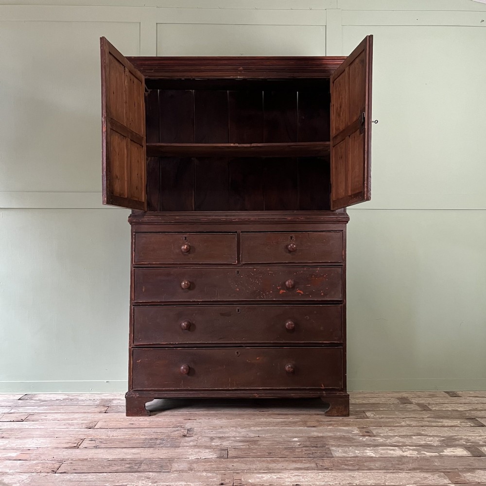 An early 19th-century Irish painted pine press cupboard with two panelled upper doors over a base section containing five drawers. View II