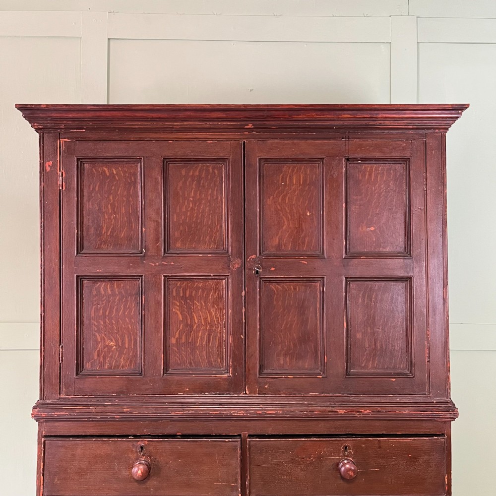 An early 19th-century Irish painted pine press cupboard with two panelled upper doors over a base section containing five drawers. View III