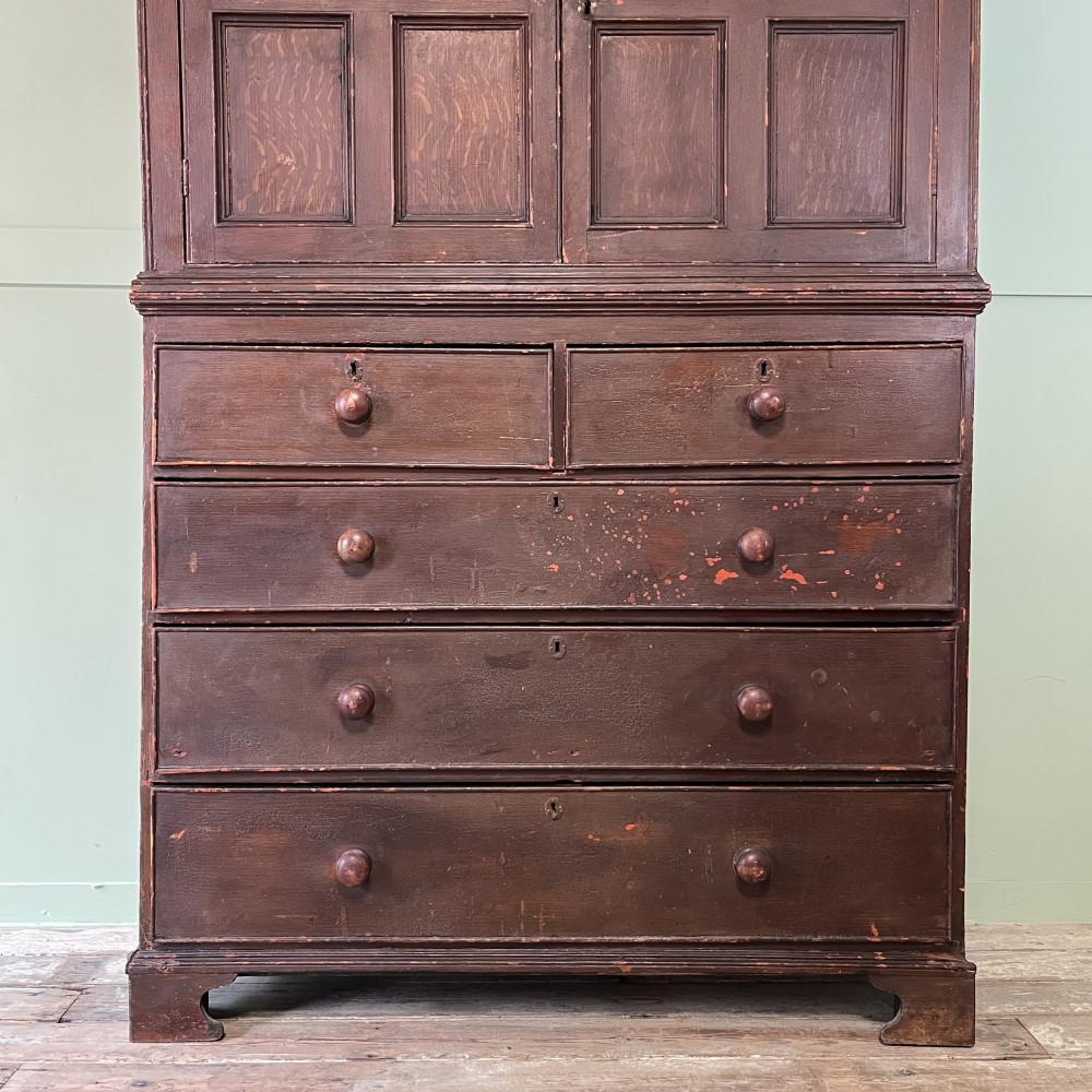 An early 19th-century Irish painted pine press cupboard with two panelled upper doors over a base section containing five drawers. View IV